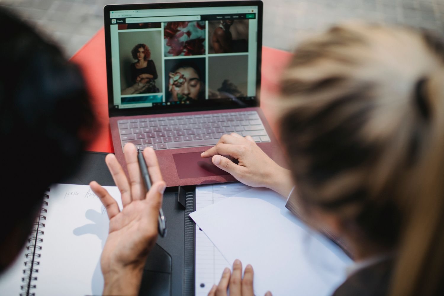 Dizüstü bilgisayarda bir web sitesini birlikte inceleyip not alan iki kişi