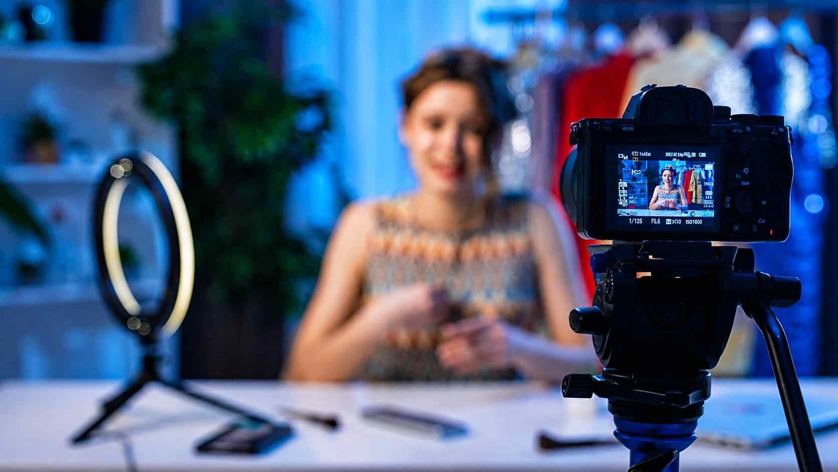 Halka ışık ve kamera karşısında video içeriği çeken içerik üreticisi